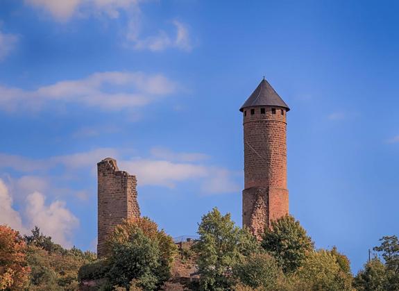 Der Turm von Burg Kirkel ragt zwischen Bäumen hervor