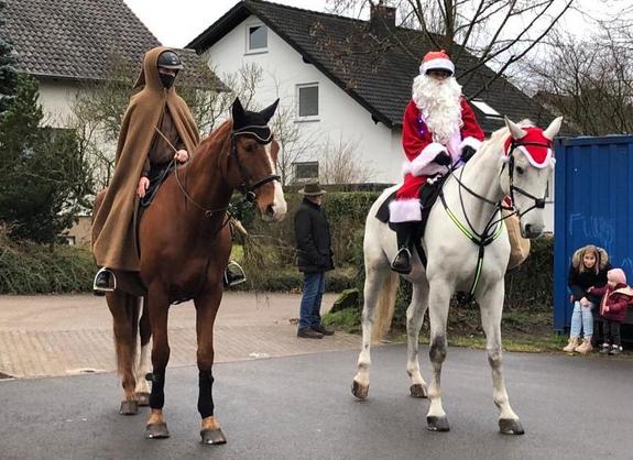 Zwei Reiterinnen verkleidet als St. Nikolaus und Knecht Ruprecht auf ihren Pferden