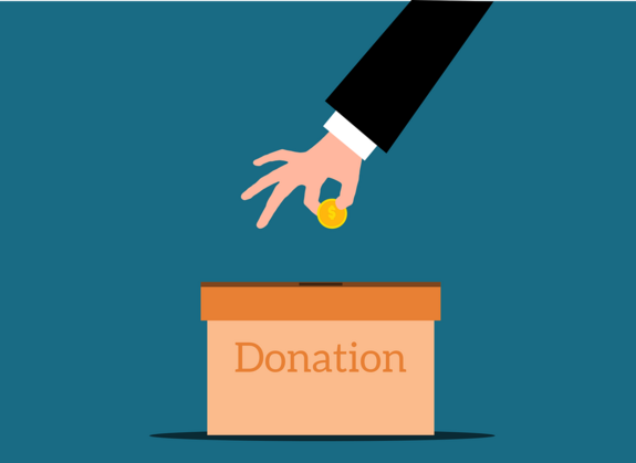 Eine Hand, die ein Geldstück in eine Kiste mit der Aufschrift "Donations" (Spenden) steckt