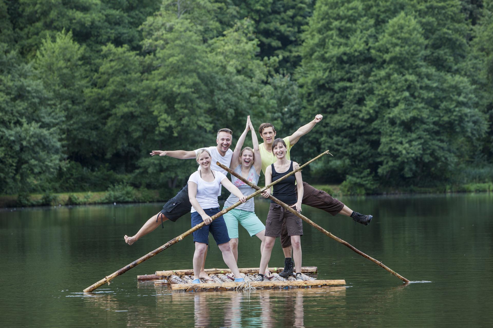 Eine Gruppe Erwachsener auf einem selbstgebauten Floß auf dem Würzbacher Weiher