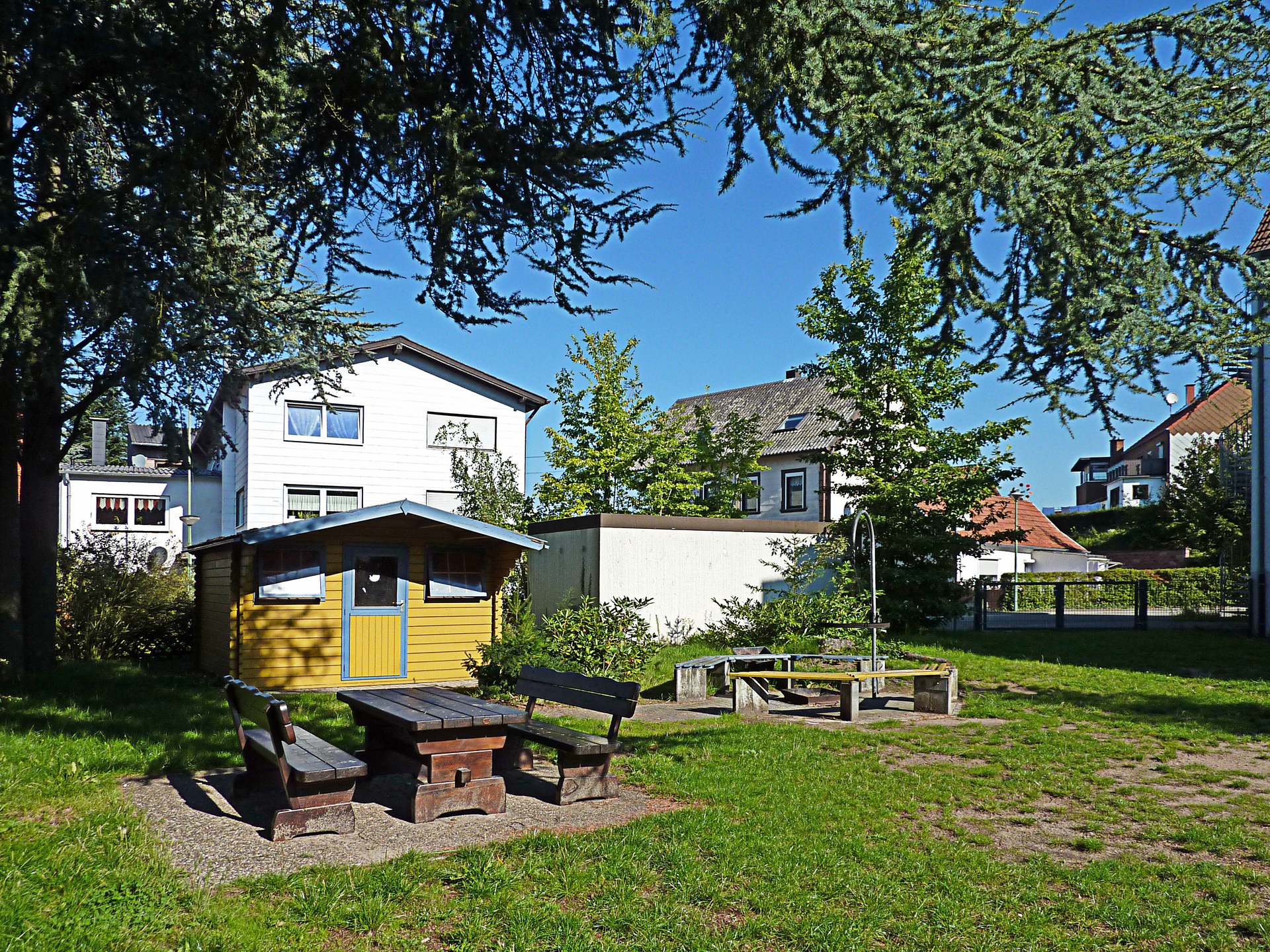 Gartenansicht Familienlandheim mit Gartenhäuschen und Sitzbank